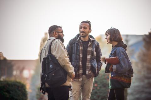 three students outside talking