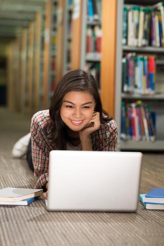 student in library on laptop